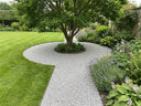 Curved gravel path around a tree held in place with Pro-Hold — no migration onto the lawn